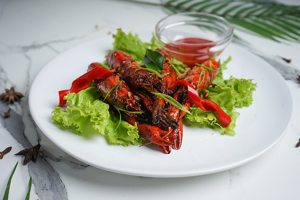 Udang Selingkuh goreng mentega dengan hiasan irisan daun bawang dan bawang bombay.