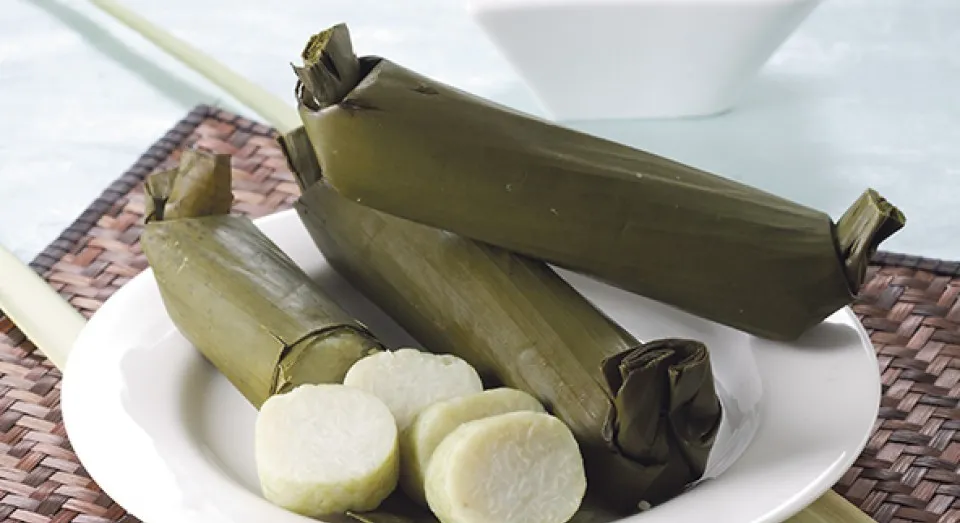 Lontong berwarna hijau cantik yang dipotong rapi di atas piring saji