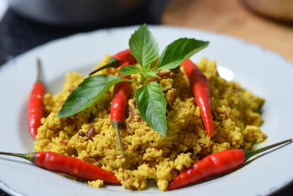 Sajian Paniki bumbu kuning dengan taburan daun kemangi dan cabai rawit utuh